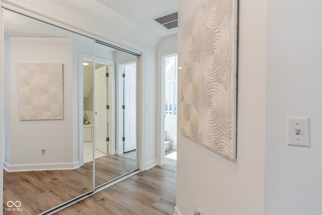 corridor with light hardwood / wood-style floors