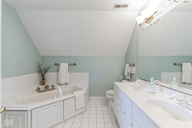 bathroom featuring lofted ceiling, toilet, a bath, double sink vanity, and tile patterned flooring