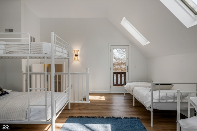 bedroom featuring vaulted ceiling with skylight and hardwood / wood-style floors