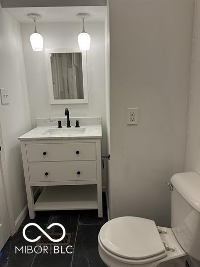 bathroom featuring tile patterned flooring, toilet, and vanity