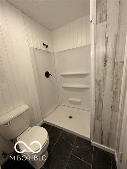 bathroom featuring tile patterned floors, walk in shower, and toilet