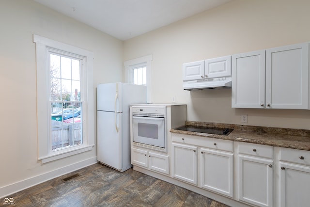 kitchen with white appliances, white cabinetry, dark hardwood / wood-style flooring, and a healthy amount of sunlight