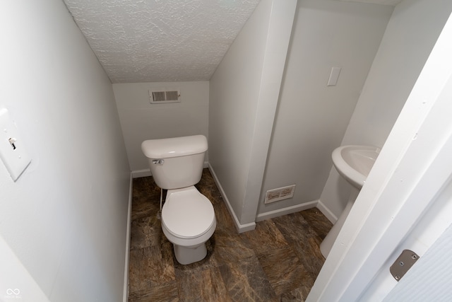 bathroom featuring hardwood / wood-style flooring, a textured ceiling, and toilet