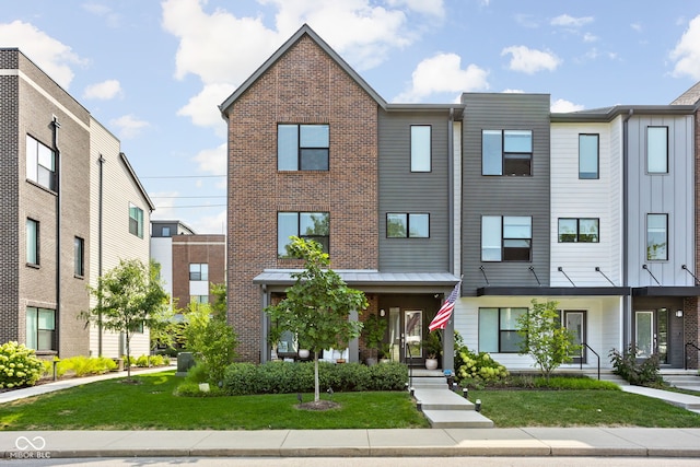 townhome / multi-family property featuring a front lawn