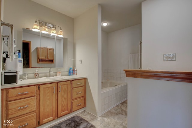 bathroom with tiled tub and vanity