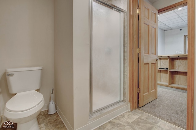 bathroom featuring toilet, a paneled ceiling, and a shower with door