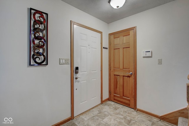 foyer entrance with a textured ceiling