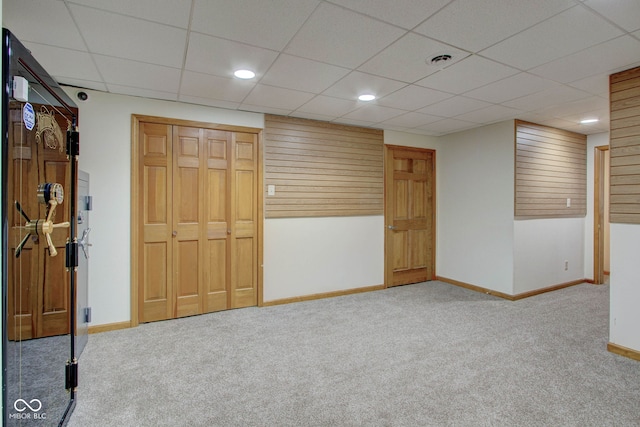 basement with a drop ceiling and carpet