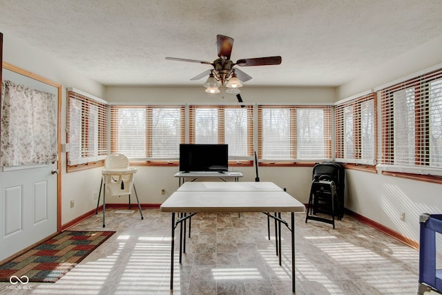 unfurnished office featuring a textured ceiling, a healthy amount of sunlight, and ceiling fan