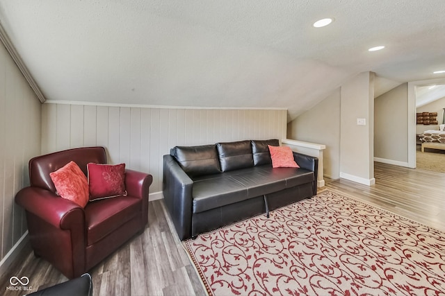 living room featuring a textured ceiling, lofted ceiling, and wood-type flooring