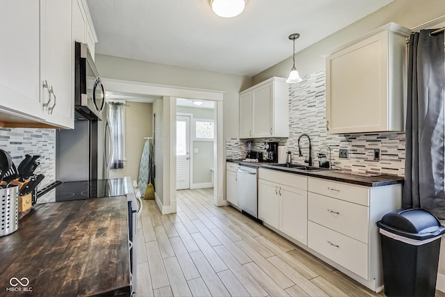 kitchen featuring sink, stainless steel appliances, decorative backsplash, and white cabinets