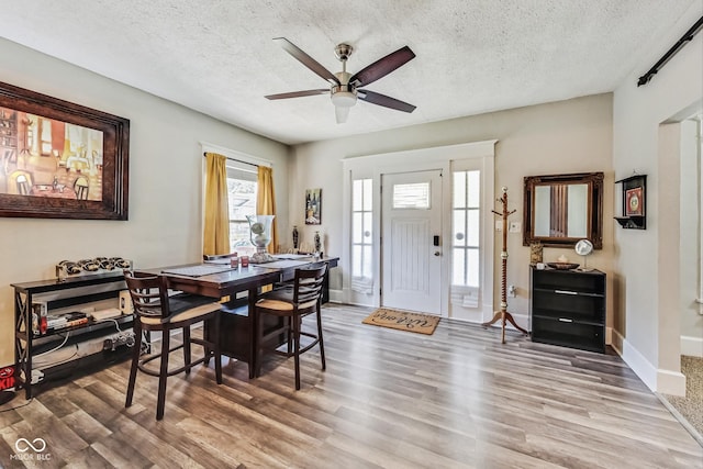 dining room featuring hardwood / wood-style floors, a textured ceiling, and ceiling fan