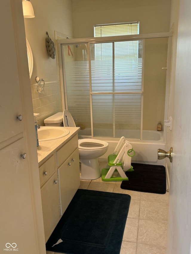 full bathroom with enclosed tub / shower combo, tile patterned flooring, vanity, and toilet