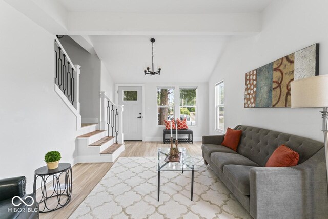 1046 Dawson St, Indianapolis, IN 46203 - living room featuring stairs, lofted ceiling with beams, wood finished floors, baseboards, and an inviting chandelier