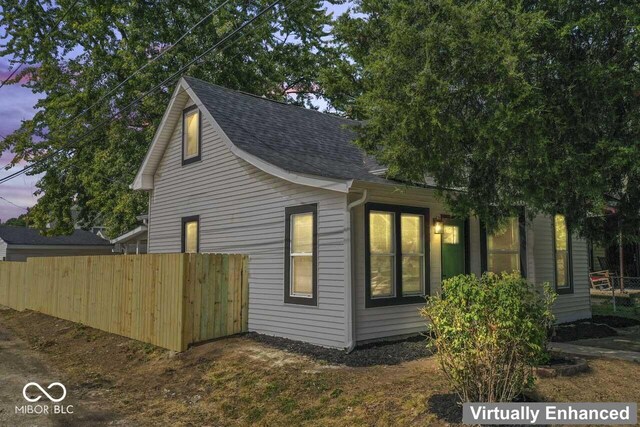 1046 Dawson St, Indianapolis, IN 46203 - property exterior at dusk featuring roof with shingles and fence