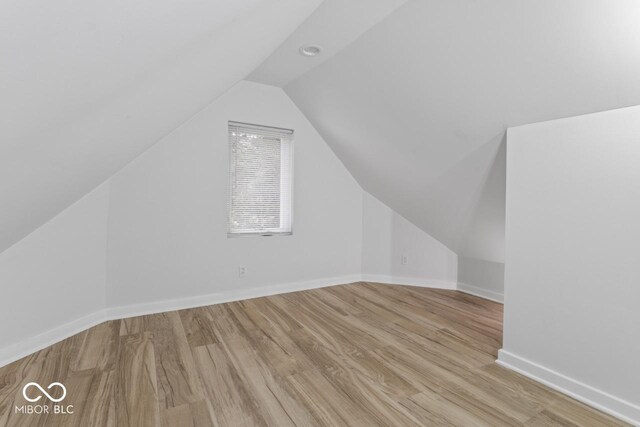1046 Dawson St, Indianapolis, IN 46203 - bonus room featuring baseboards, wood finished floors, and vaulted ceiling
