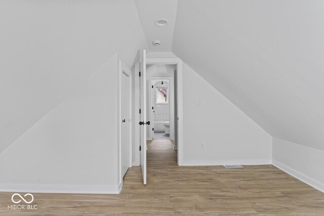 1046 Dawson St, Indianapolis, IN 46203 - additional living space with baseboards, lofted ceiling, and wood finished floors