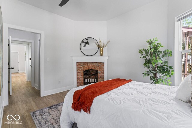1046 Dawson St, Indianapolis, IN 46203 - bedroom with a brick fireplace, baseboards, and wood finished floors