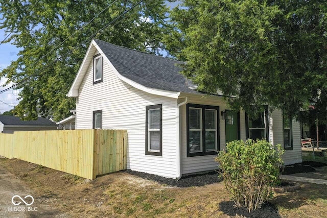 1046 Dawson St, Indianapolis, IN 46203 - view of side of property with a shingled roof and fence