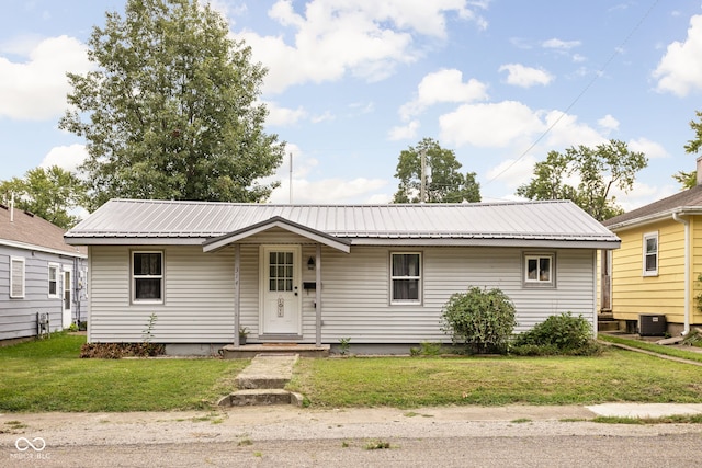 ranch-style home with central AC unit and a front lawn