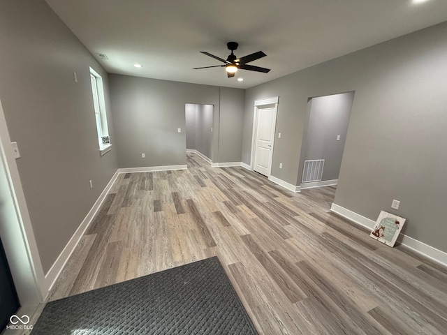 empty room with ceiling fan and light hardwood / wood-style flooring