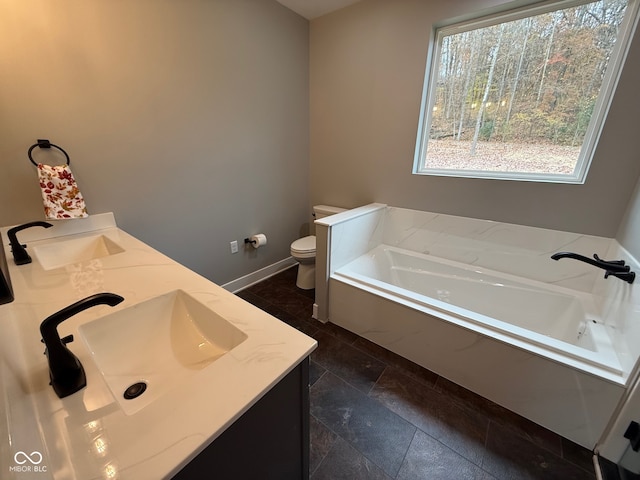 bathroom featuring vanity, toilet, and tiled tub