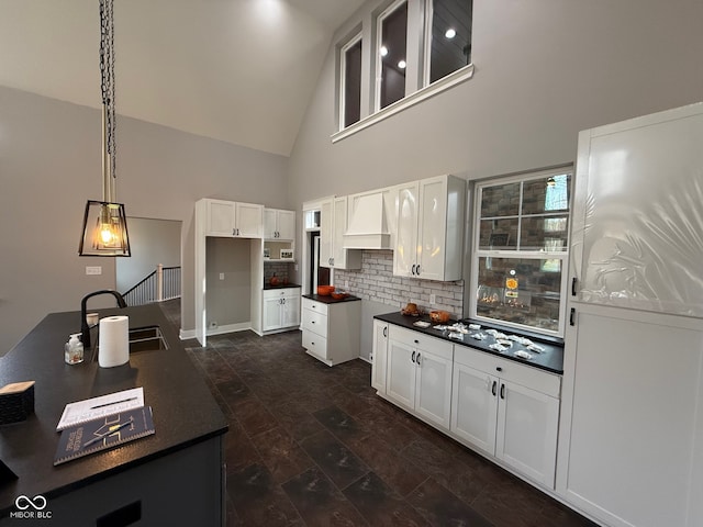 kitchen featuring white cabinetry, sink, dark hardwood / wood-style flooring, high vaulted ceiling, and pendant lighting