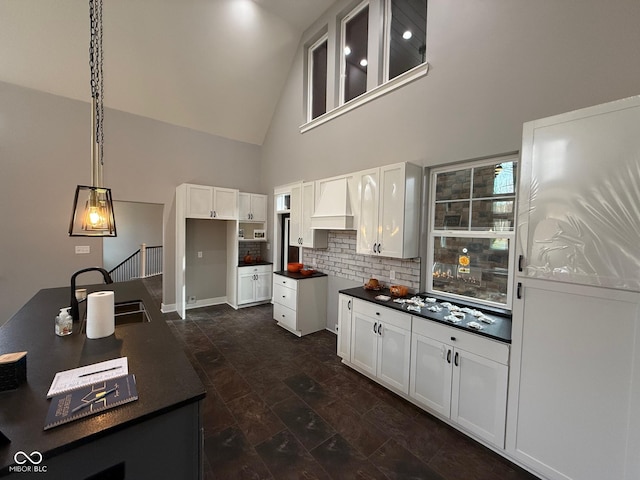 3380 N Pine Song Dr, Martinsville, IN 46151 - kitchen featuring a sink, decorative backsplash, dark countertops, high vaulted ceiling, and white cabinetry