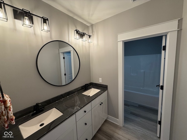 bathroom featuring vanity, shower / bathtub combination, and wood-type flooring