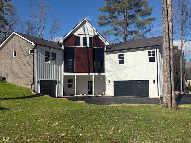 view of front of home with central air condition unit, a front lawn, and a garage