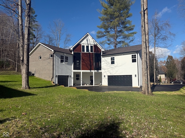 exterior space featuring a yard, a garage, and central air condition unit