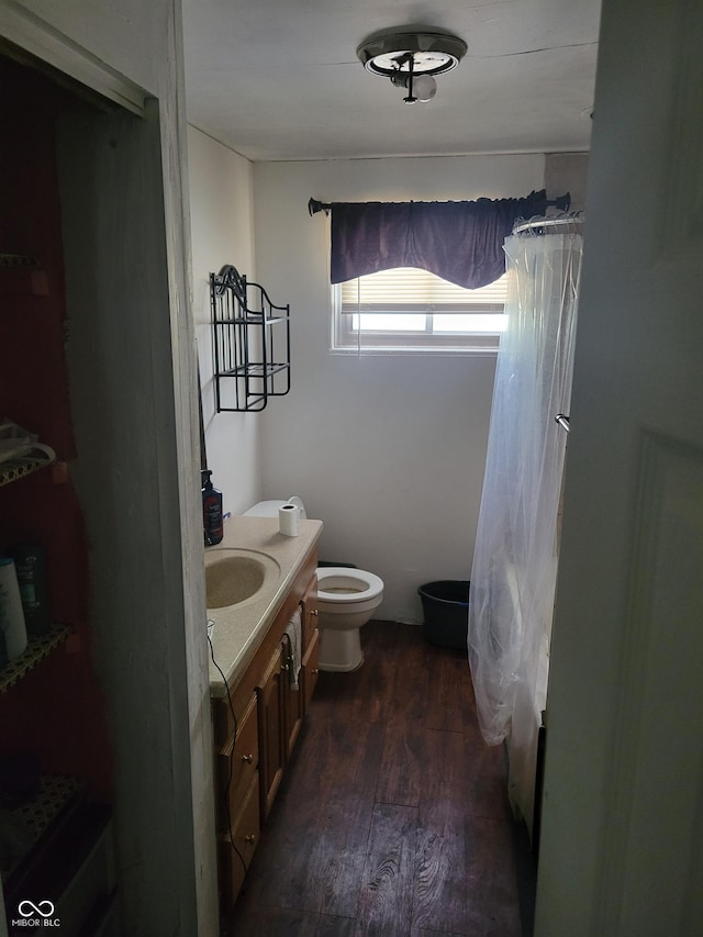 bathroom with toilet, curtained shower, wood finished floors, and vanity