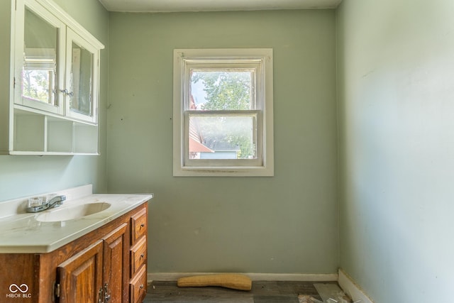 bathroom with baseboards, wood finished floors, and vanity