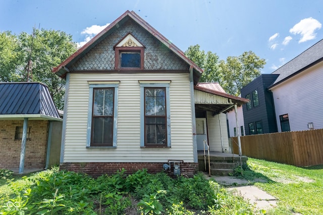 view of front of house featuring fence and metal roof