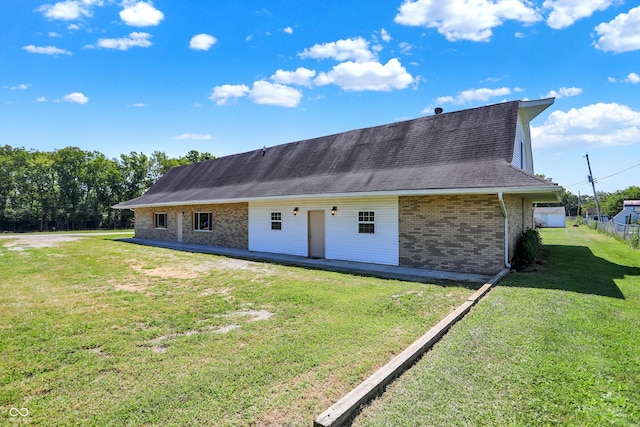 rear view of house featuring a yard and a garage