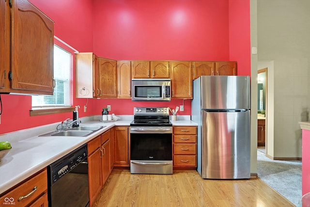 kitchen with stainless steel appliances, light hardwood / wood-style floors, and sink