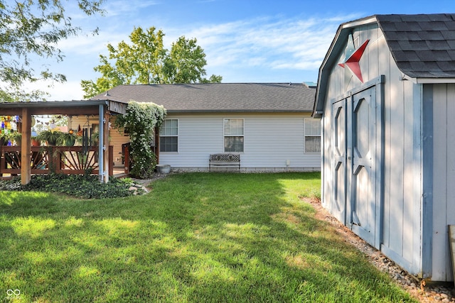 back of property featuring a yard and a storage unit