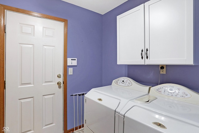 laundry area with washer and clothes dryer and cabinets