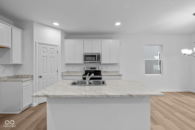 kitchen featuring light wood-type flooring, stainless steel appliances, white cabinetry, and sink