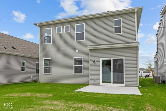 rear view of property with a lawn, central AC unit, and a patio area