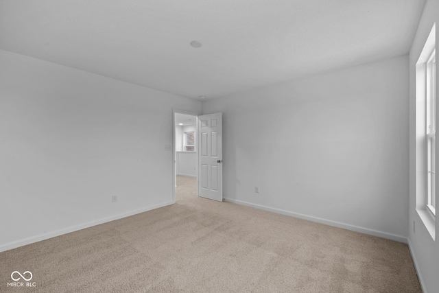 carpeted spare room featuring a healthy amount of sunlight