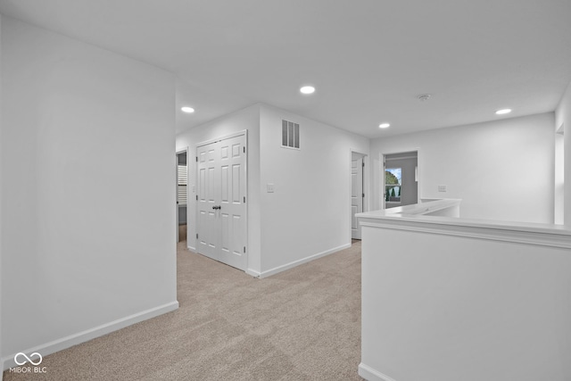 hallway with light colored carpet