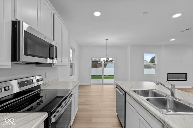 kitchen featuring white cabinets, stainless steel appliances, light hardwood / wood-style flooring, and sink