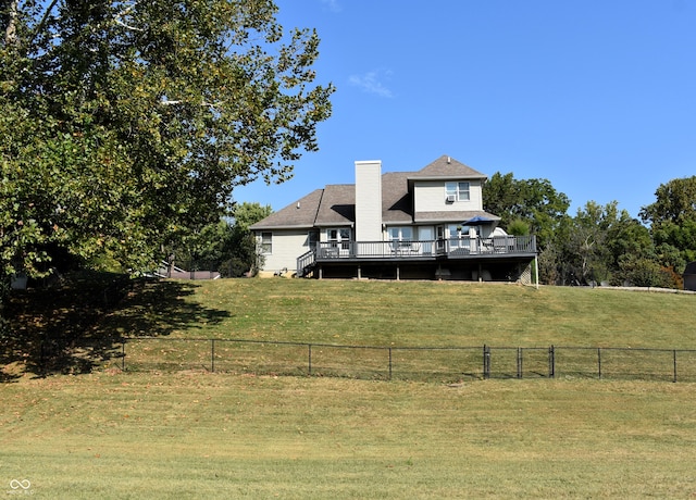 back of property featuring a lawn and a deck