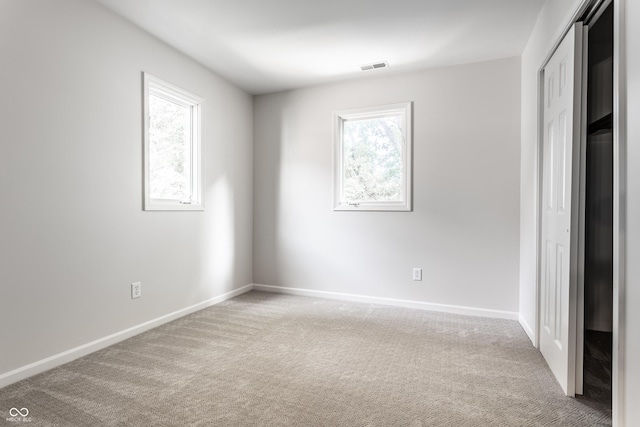 unfurnished bedroom featuring carpet flooring, baseboards, visible vents, and a closet