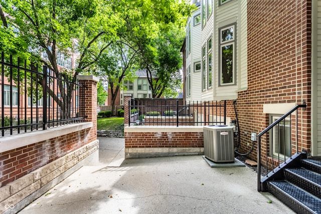 view of patio / terrace featuring central air condition unit and fence