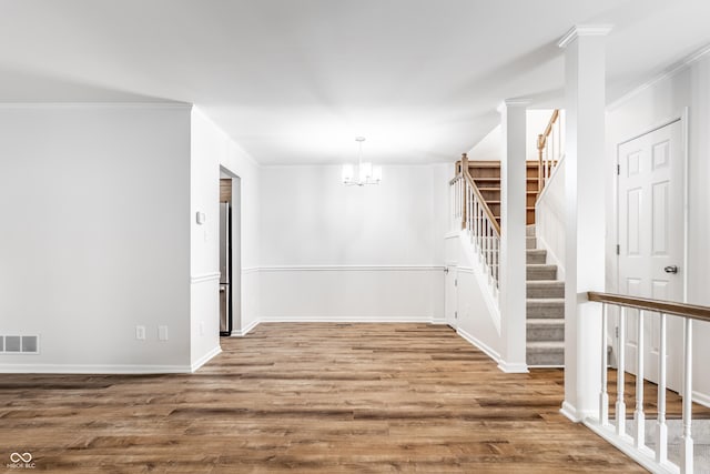 spare room with visible vents, wood finished floors, and stairway