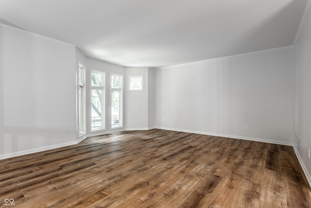 unfurnished room with baseboards, wood finished floors, and ornamental molding