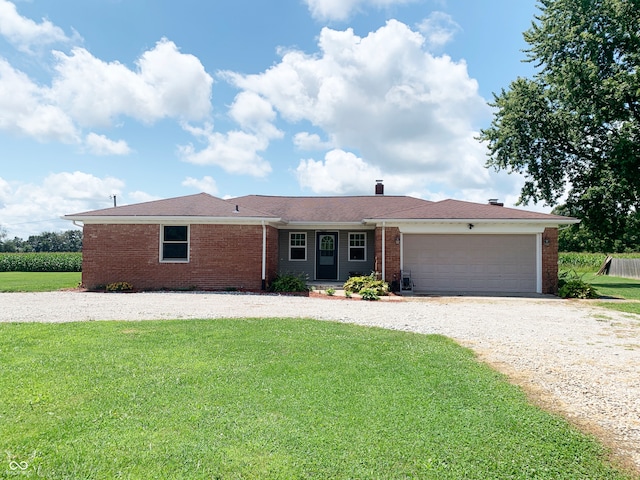 single story home featuring a garage, a front yard, brick siding, and driveway