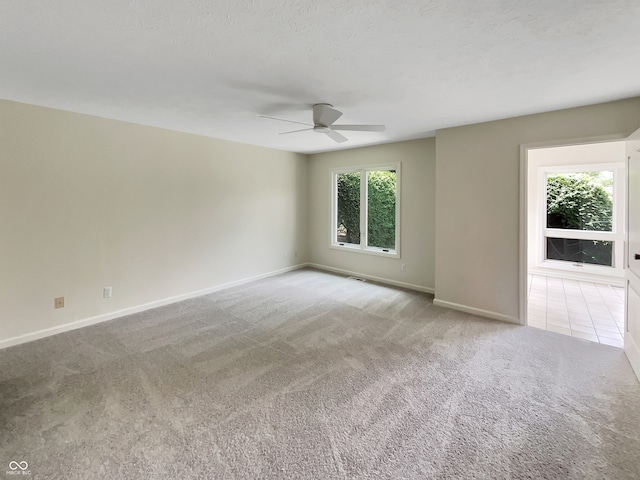 unfurnished room with ceiling fan and light carpet